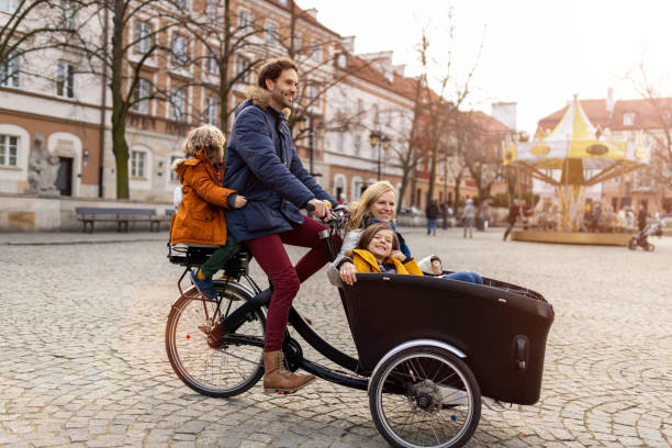 Young family enjoying spending time together, riding in a cargo bicycle Young family enjoying spending time together, riding in a cargo bicycle adult tricycle stock pictures, royalty-free photos & images