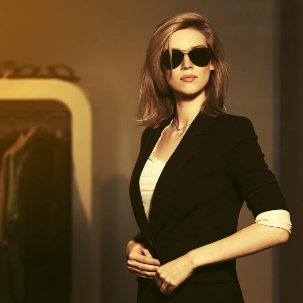 Young fashion blonde woman in sunglasses and black suit jacket stock photo