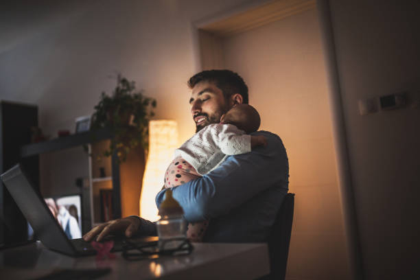 Ung pappa arbetar hemma med sin bebis flicka