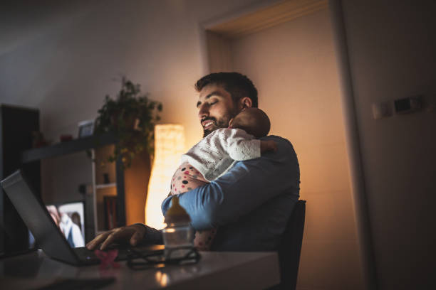 Young father working at home with his baby  girl