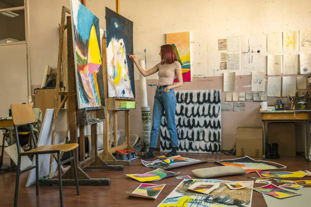 Joven artista femenina pintura en su taller - foto de stock