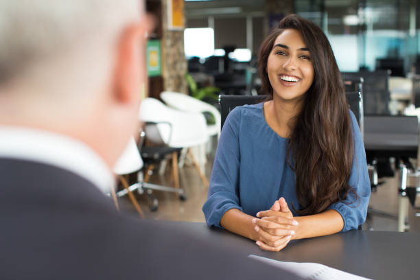 Young female candidate laughing at job interview stock photo