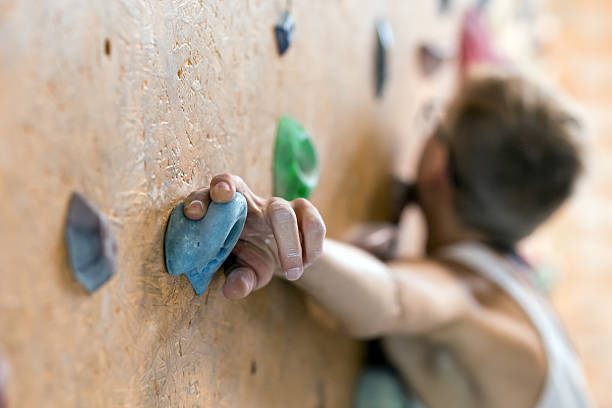 Young Female Climber on wall of indoor climbing gym stock photo
