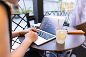 オープンカフェでソフトウェアを開発する若い女性エンジニア