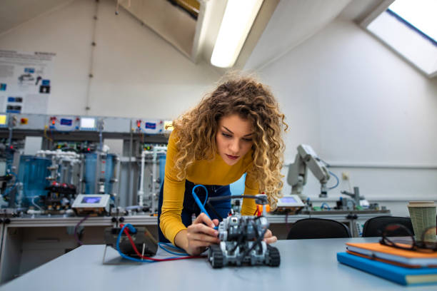 Young female engineer works on new robot project stock photo
