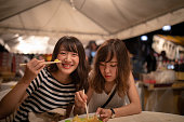 前夜祭でジャガイモを食べる若い女性の友人