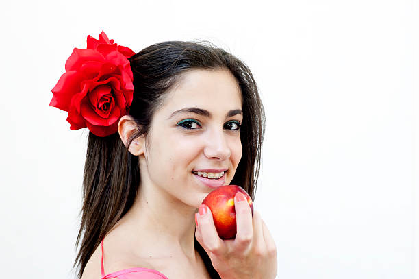Young female isolated on white background eats nectarine stock photo