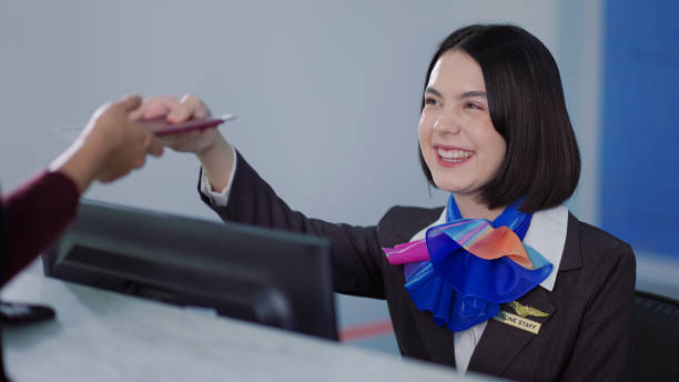 Young female staff at airport check in desk stock photo