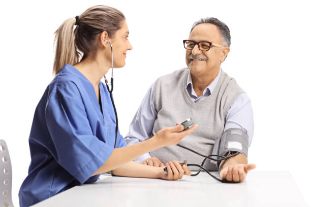 Young female urse checking blood pressure to an elderly man stock photo