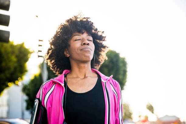 Young Fit Black Woman Listening to Music During Workout A young black woman adjusts her headphones during her workout relief emotion stock pictures, royalty-free photos & images