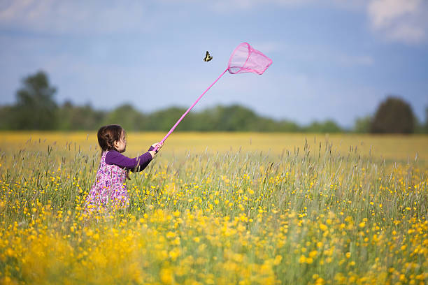 Young Girl Chasing Butterfly stock photo