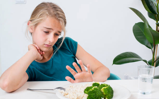 Young girl does not want to eat stock photo