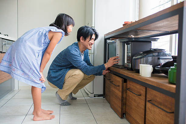 台所で父親を助ける若い女の子 - 日本　家電 ストックフォトと画像