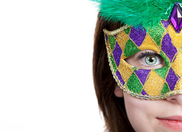 Young girl in a mardi gras mask with copy space A young girl in a gold, purple and green mardi gras mask with copy space mardi gras women stock pictures, royalty-free photos & images