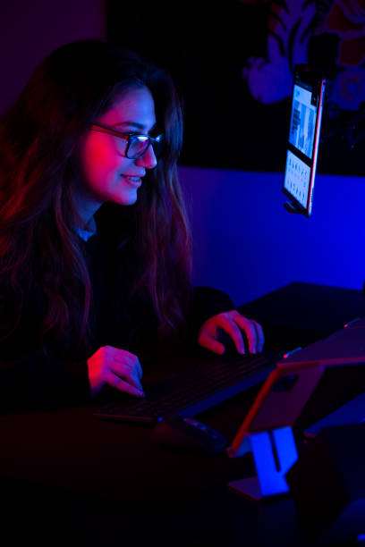 Young girl playing computer game at night stock photo