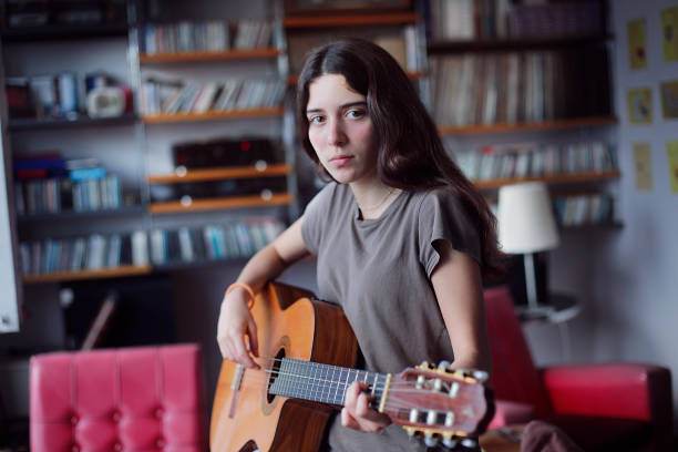 young girl playing guitar stock photo