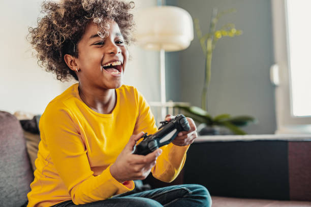 Young girl playing video games Young African American little girl at home with playing video games video game stock pictures, royalty-free photos & images