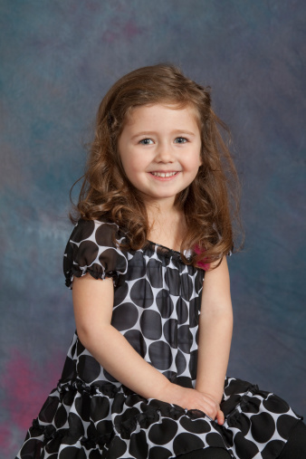 Portrait of a four-year-old  (almost 5) girl with against a studio background.  Model  has blue eyes and has a happy smile.See other related images here: