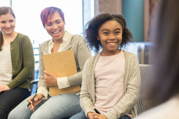Young girl talks with school counselor Cute African American schoolgirl talks with a teacher or school counselor. school counselor stock pictures, royalty-free photos & images