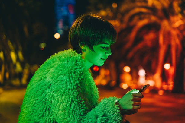 Young girl using smart phone at night in Barcelona stock photo