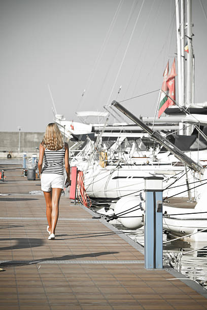 Young girl walking to the yachts stock photo