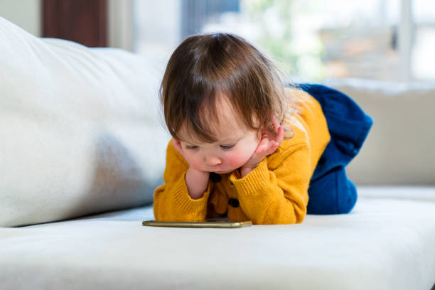 Young girl watching TV on a smartphone stock photo