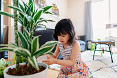 自宅で植物に水をやる若い女の子