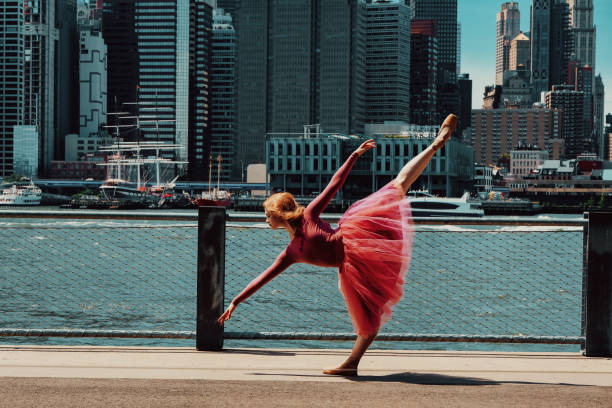 young gorgeous ballerina dancing on street, downtown Brooklyn, New York City financial district cityscape stock photo