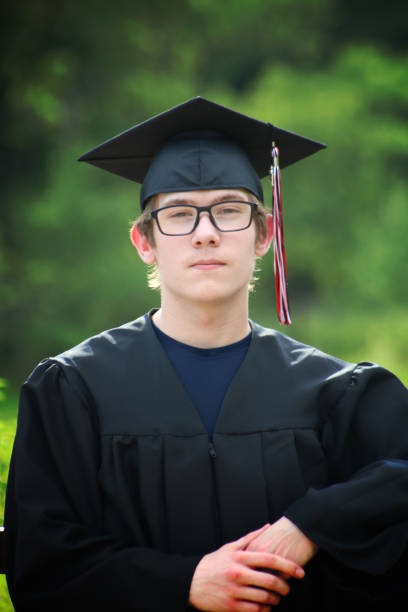 Young Graduate in Cap and Gown Head & Shoulders Accomplished Look stock photo