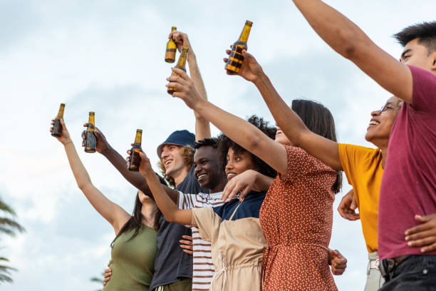 Young group of multiracial friends having fun drinking beer at summer party stock photo