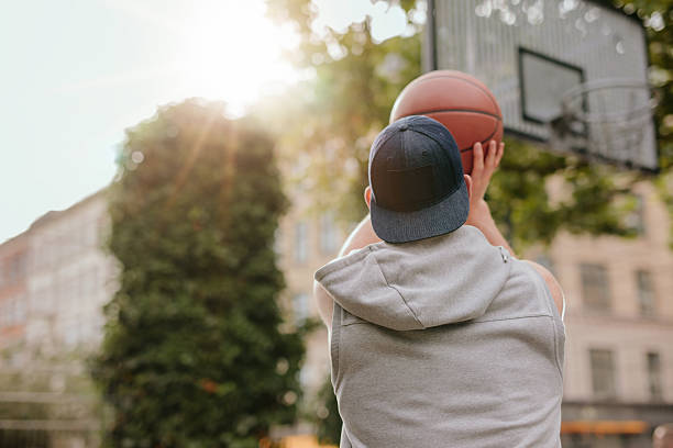 young guy playing basketball - basketball player back stockfoto's en -beelden