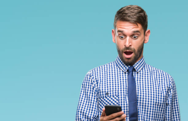 Young hadsome man texting sending message using smartphone over isolated background scared in shock with a surprise face, afraid and excited with fear expression Young hadsome man texting sending message using smartphone over isolated background scared in shock with a surprise face, afraid and excited with fear expression worried man funny stock pictures, royalty-free photos & images