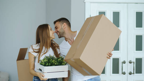 Young happy couple walking into new house after moving day and kiss each other stock photo