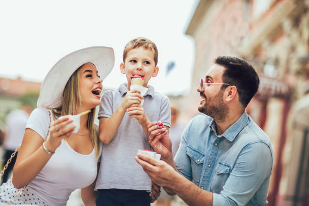 junge glückliche familie verbringt ihr wochenende mit sohn sie fressen das eis - ice cream fancy stock-fotos und bilder