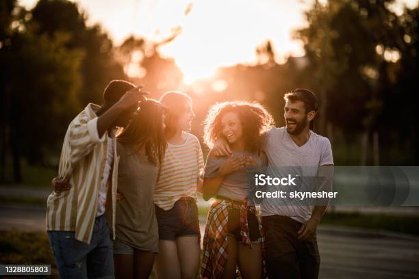 Young happy millennial people talking while enjoying in their walk on the street.
