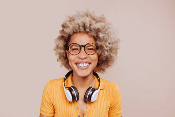 Young happy smiling latin american afro woman listening to music stock photo