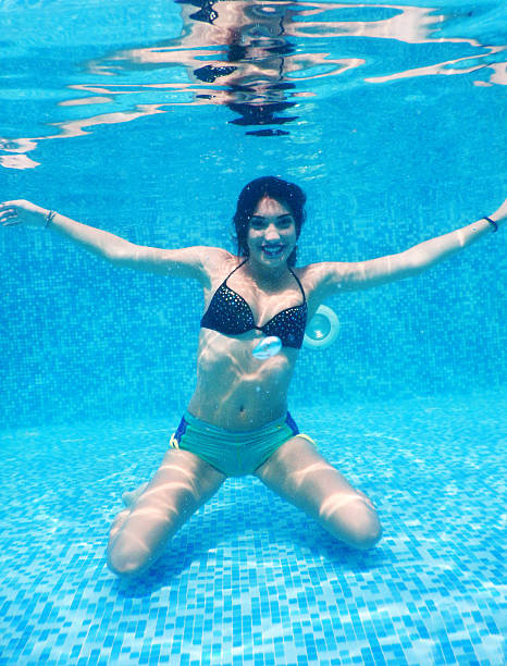 Nude beautiful girl is underwater. Woman relax in sea 