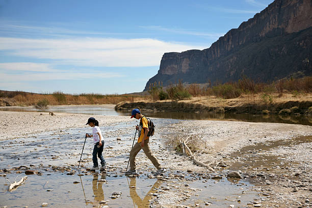 Young Hikers Crossing Stream stock photo