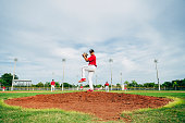 istock Young Hispanic baseball pitcher in wind-up position 1174867124