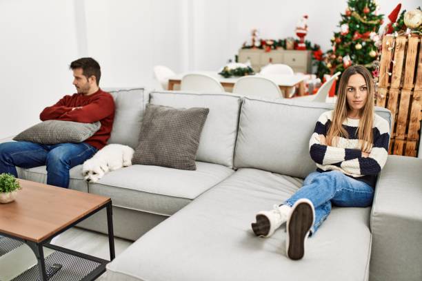 Young hispanic couple with problems sitting on the sofa in silence at home. stock photo