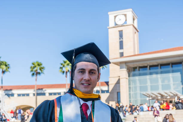 Young Hispanic man graduation day Young Hispanic man in his graduation day uniform universities in texas stock pictures, royalty-free photos & images