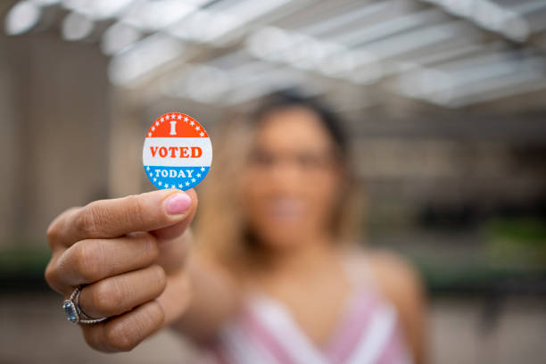 Young Hispanic Woman with I voted Sticker A young Hispanic woman with her I voted sticker after voting in an election. voting rights stock pictures, royalty-free photos & images