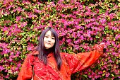 彼女の背景に中国のフリンジの花と若い日本女性ポーズ