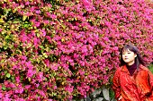 彼女の背景に中国のフリンジの花と若い日本女性ポーズ