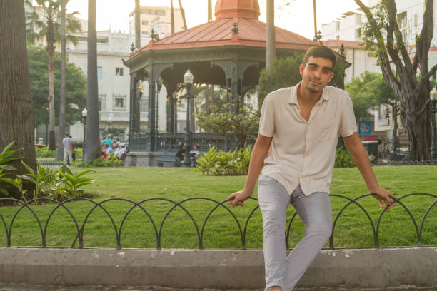 Young latin male portrait, traveling, sitting and posing at Parque Seminario or Iguanas' Park, Guayaquil, Guayas, Ecuador stock photo