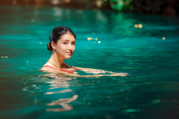 young Latina woman standing in blue green waters of Rio Blanco in Costa Rica stock photo