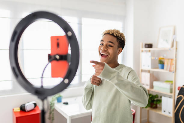 Young male creator recording online media video on his room stock photo