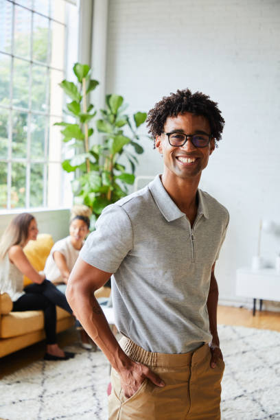 Young male designer smiling while standing in a modern office stock photo