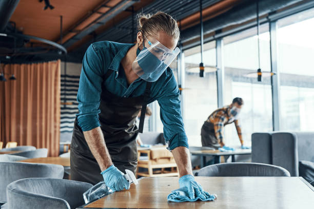 Young male waiters in protective workwear stock photo