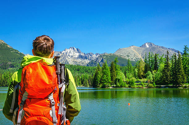 Young man admires mountain lake Strbske Pleso stock photo